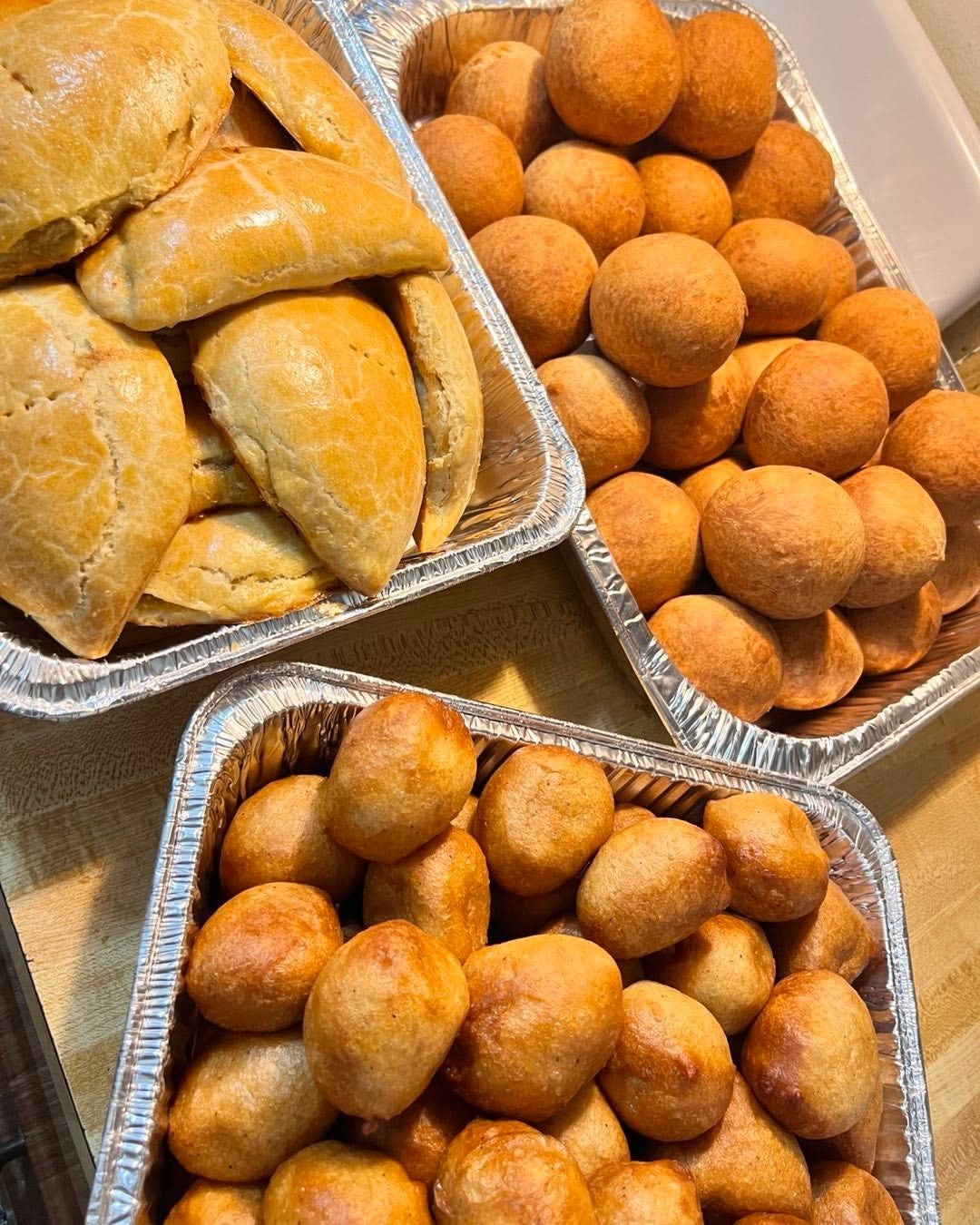 Freshly prepared pastries and golden puff-puff in catering trays